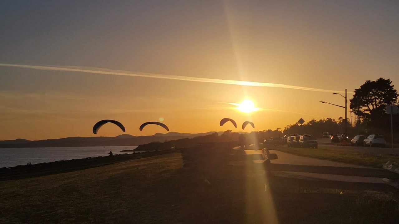 Kite surfers on the water at sunset along the Victoria waterfront